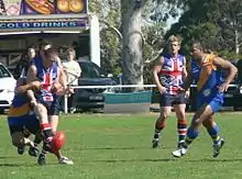 A British Bulldog gets a kick away despite close checking from a Nauruan opponent in Britain's round 2 loss