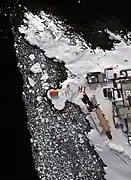 Residents use their red parkas to send a greeting to NASA's DC-8.