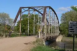 Bridge on gravel road, consisting of one steel through truss