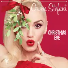 A red background displaying one of Gwen Stefani's hands holding a piece of mistletoe above her head; the words "Gwen Stefani, Christmas Eve" also appear in a white typeface.