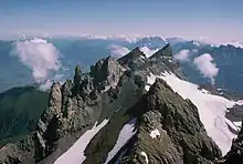 Six rocky peaks surrounded by earth and snow.