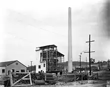 Building site. A chimney has been erected and scaffolding has gone up.