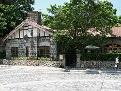 Single storey stone building with chimney and gabled tiled roof