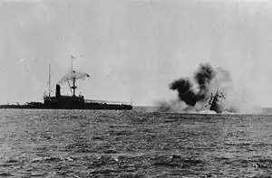 Photo of a ship sinking by the bow, with another ship close by