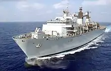 A large Royal Navy ship on the open sea, taken from a helicopter