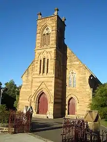 Larger stone church against a blue sky