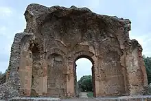 Half-missing building at Hadrian's Villa showing domed interior composed of orange peal-like sections rising from arched niches and door