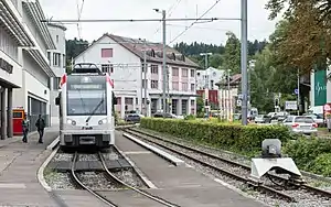 Silver vehicle on track next to the station