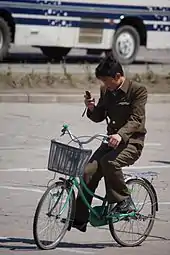 Cyclist using a mobile phone, Hamhung, 2012