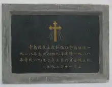 A dark granite tombstone with Chinese writing