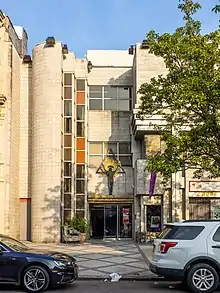 the front of a cream-colored building in Harlem, New York