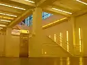 View of a below ground stairwell leading to the main floor in yellow light