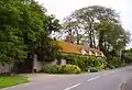 Hatford Cottage, with the former Holy Trinity parish church to the right