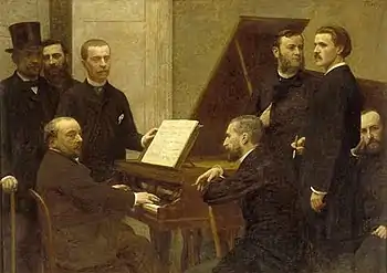 group of middle-aged men standing and sitting round a piano