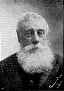 portrait photo of a grey-haired man with a full beard in his 60s or early 70s