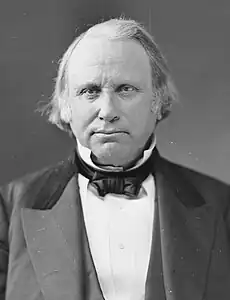 A head-and-shoulders, black-and-white photograph of a middle-aged man in formal attire. His hair appears to be grey. His expression is sober and dignified.