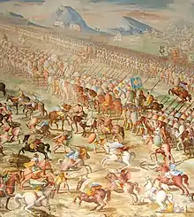 A painting of a battle with a long line of mounted riders side by side in front of a line of marching men. In front of the riders are a number of individual horsemen fighting.