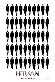 Five rows of ten indistinct figures. The forty-seventh figure is bald, wearing a suit with a white shirt and red tie.