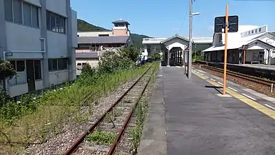 The passing loop is not much used and overgrown with weeds. In the distance can be seen the level crossing, with the west entrance to the left, under the footbridge.