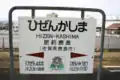 Station name board. Note the graphic of the Yūtoku Inari Shrine which is near the station.