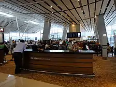 Interior view of T1 Satellite Concourse, Hong Kong International Airport. Central internet kiosk with coffee shop behind. (2013)