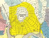 Multicoloured map with contour lines depicting a circular, ice-capped mountain and two glaciers feeding two streams.