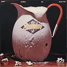 A pitcher of beer, labeled "David Bromberg Band", on a bar, with some popcorn