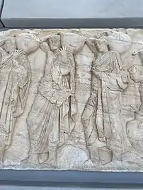 Three young men holding "hydriai" (water jugs), part of the Panathenaic procession depicted in the Parthenon frieze.