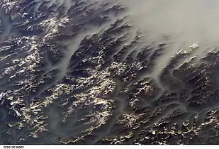 Clouds fill the valleys, but not the mountaintops. From the ISS in June 2006.