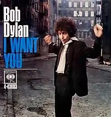 A record cover showing Bob Dylan with his hands raised.