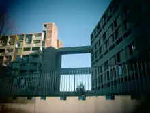 This shows the brutalist estate with the bridge in the top-middle of the image. It shows the original graffiti pattern returned, and white neon lights placed over it.