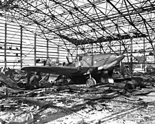 A damaged airplane in a destroyed hangar