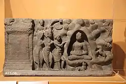 The same scene in a c. 2nd-century relief from Loriyan Tangai, Gandhara. The Buddha is shown in Indrasala cave.