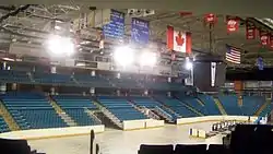 Interior view of ice hockey rink surrounded by seats coloured blue