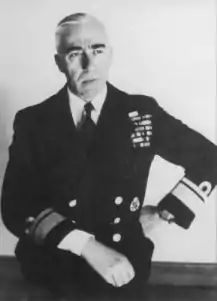 Seated middle-aged man in naval uniform, looking right