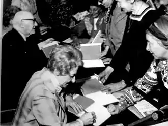 Irene Lieblich signs autographs alongside Isaac Bashevis Singer.