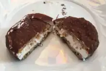 round ice cream sandwich, coated in a thin layer of chocolate coating and cut in half