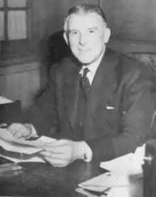 A man sitting at a desk holding papers