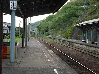 A view of the station platforms. The siding can be seen branching off to the left. To the right, grass can be seen growing over the unused track 2. Track 3 can be seen branching to the extreme right on the other side of the island platform.