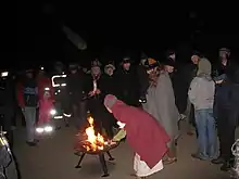 A group of individuals standing outdoors in the dark