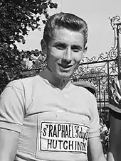 A man wearing a cycling jersey while smiling.