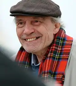 Man in a hat and red scarf smiling