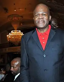 An older gentleman in a blazer and red shirt