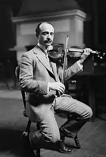 Jan Hambourg seated, playing a violin