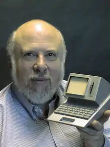 Image of Jef Raskin holding a model of the Canon Cat