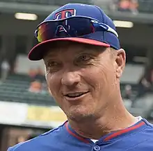 A man wearing a blue baseball jersey and cap