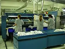 A feeder where linen is placed and which takes the linen to the ironer and folder