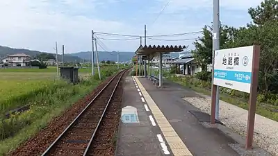 Platform and track of Jizōbashi Station. Note the trackbed of the former track 1 on the other side of the platform and the path from the station building which crosses it. The track kinks in the distance, indicating it once merged with the former track 1 over there.