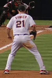 A man in a baseball uniform with his back to the camera