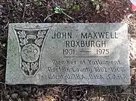 Flat grey granite marker engraved with Roxburgh's name and a CAHA logo